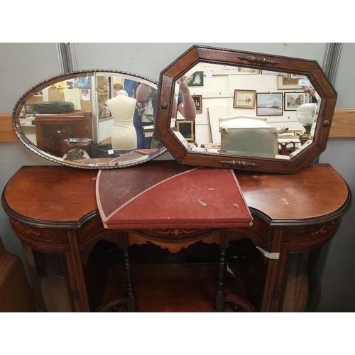 553 - An oval bevelled glass mirror in silvered frame, 65 cm x 36 cm; another in oak frame