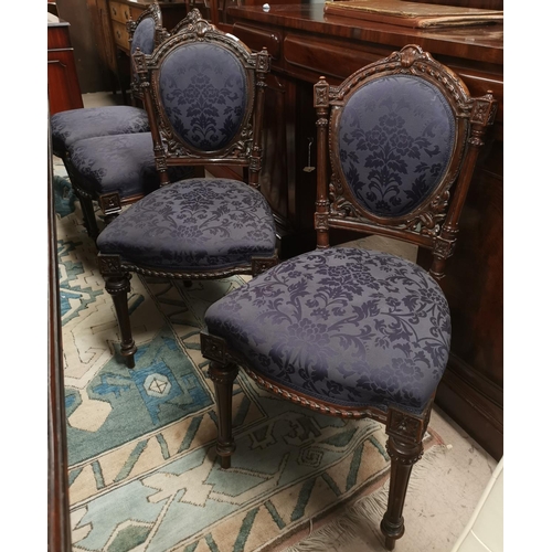 637 - A set of 4 Victorian carved walnut chairs with arched tops and purple fabric