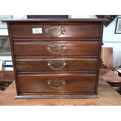 374 - A walnut jewellery / correspondence cabinet with 4 drawers and brass drop handles