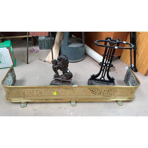 375 - A Victorian pierced brass fender; a Victorin cast iron lion doorstep and a stickstand