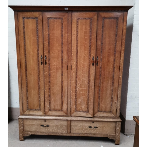547 - An early 20th century oak Arts & Crafts wardrobe by Arthur W Simpson of Kendal, with lines of carved... 