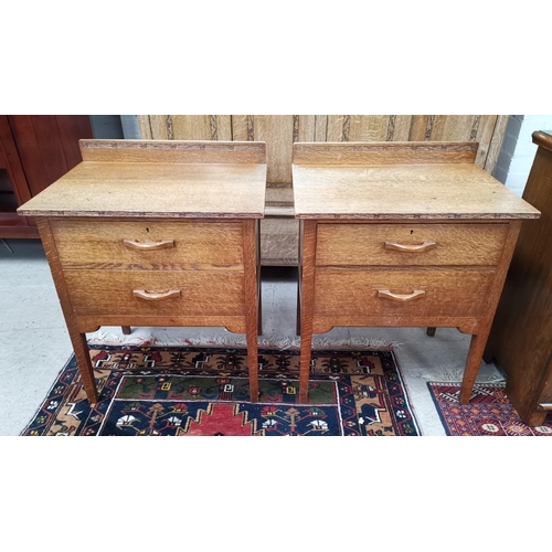 547A - A similar pair of Arts and Crafts oak bedside cabinets, with two drawers.