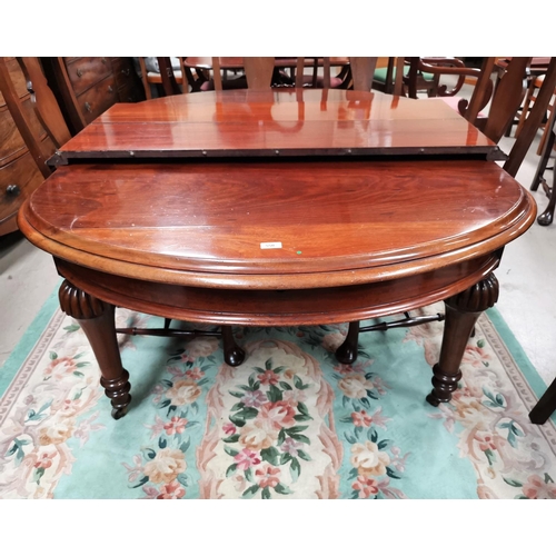 550 - A late 19th/early 20th century mahogany dining table of rounded rectangular form, with wind out acti... 