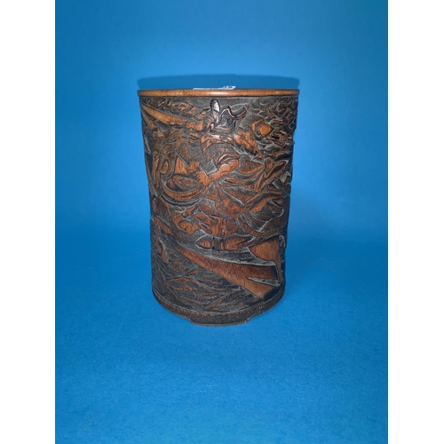 318A - An oriental carved bamboo brush pot depicting man charging on horseback height 13cm