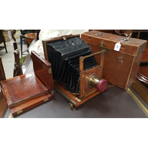 492 - A 19th century mahogany and brass half plate folding camera by Adams & Co Ltd, with 3 plate holders ... 