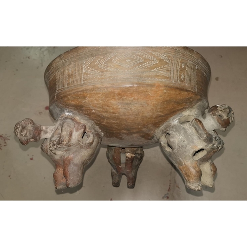 524 - A South American (possibly pre Columbian) clay bowl on top of three feet depicted as nodding men, ca... 