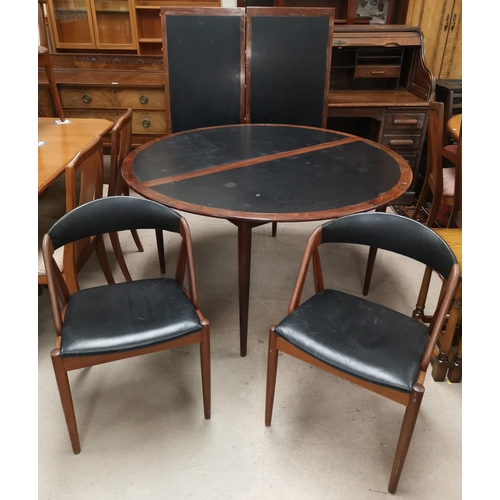 538 - A 20th Century designer Scandinavian rosewood table and chairs, the table a circular extending dinin... 