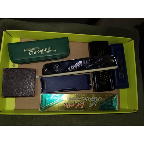 496 - A Hohner Blues harp; 2 others; 3 harmonicas; a cigarette lighter