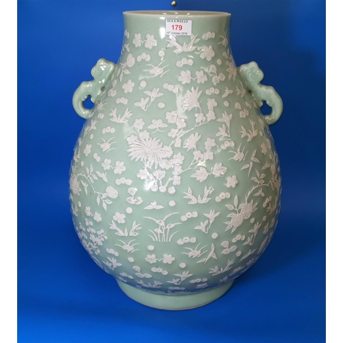 179 - A very large Chinese cermic celadon glaze vase with raised white floral and naturalistic decoration,... 