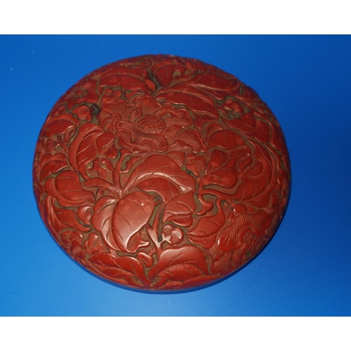 175 - A Chinese red cinnabar lacquer circular lidded box decorated with flowers, diam 17cm