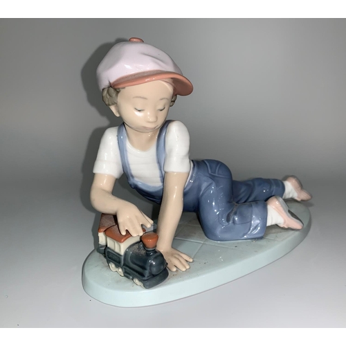 7 - A Lladro figure - boy kneeling and playing with a toy train, stamped 'Collectors' Society 1992', imp... 