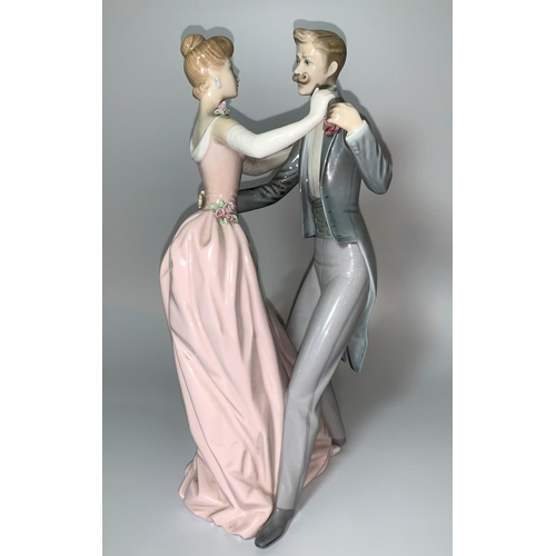 11 - A Lladro group - An Edwardian lady and gentleman in evening dress, waltzing, height 31cm