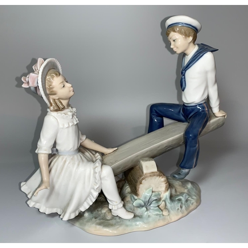 16 - A Lladro group - girl and boy in sailor outfit on a sea saw, overall length 27cm (1 finger a.f.)