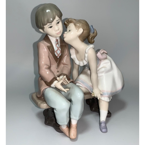 4 - A Lladro group - girl kissing a boy seated on a bench, 10th Anniversary 1985-1995