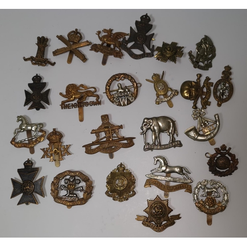 541 - A collection of 24 British military cap badges
