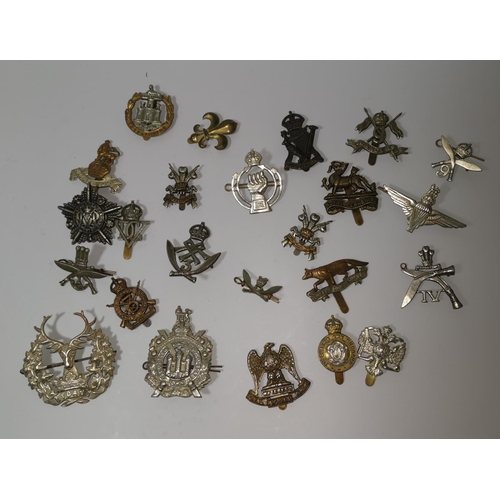 543 - A collection of 24 British military cap badges