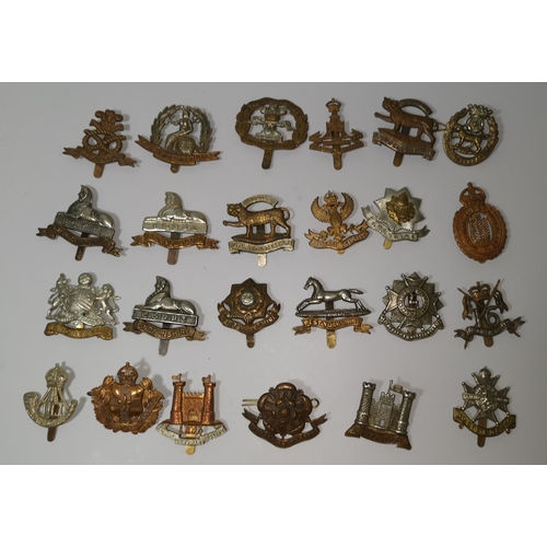 544 - A collection of 24 British military cap badges
