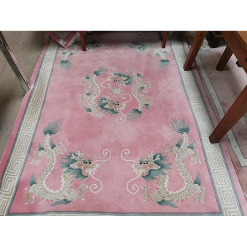 640 - A Chinese rug with dragon pattern on pink ground, 110