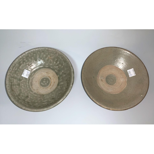 132b - A near matching pair of shallow stoneware bowls, grey with part celadon glaze, on raised foot rims, ... 