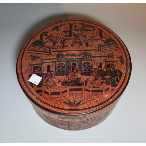 122 - A 19th century Burmese red lacquer circular box and cover, with figural decoration on black ground, ... 