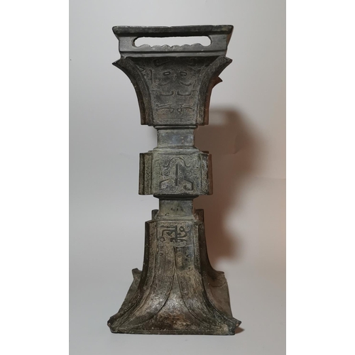 127 - A Chinese bronze 'Gu' form vase, late Ming, shallow moulded key decoration with stylized inscription... 