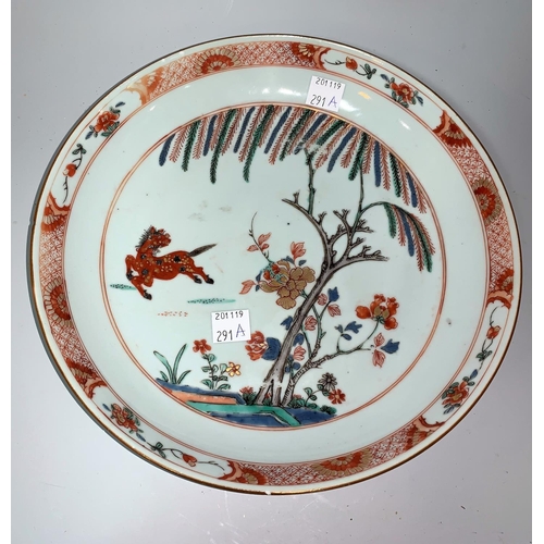291a - A Chinese Kangxi shallow dish decorated with prancing horse, flowers and trees, in burnt orange, gre... 