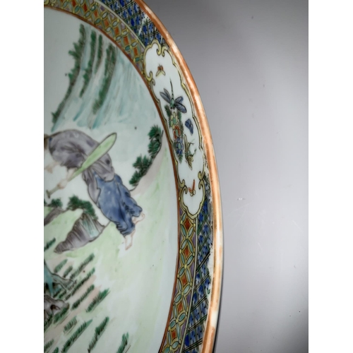 298 - A 19th century Chinese Cantonese shallow dish decorated in polychrome with figures by a tree, 4 char... 