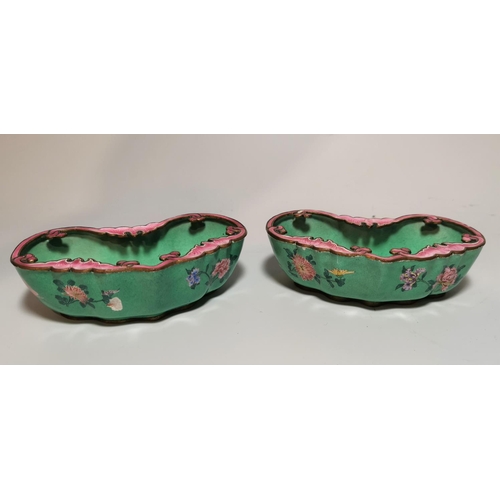 145 - A pair of Chinese kidney shaped canton enamel brush pots decorated with pink and blue flowers agains... 