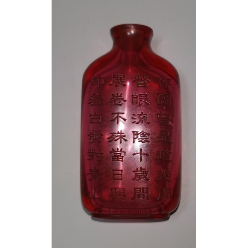 143 - A Chinese ruby coloured glass snuff bottle engraved with landscapes to one side, 28 character text t... 