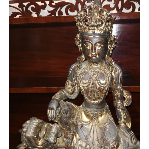 243 - A large Chinese gilt-bronze figure of Guanyin seated on a ferocious Buddhist lion, on lotus base, he... 