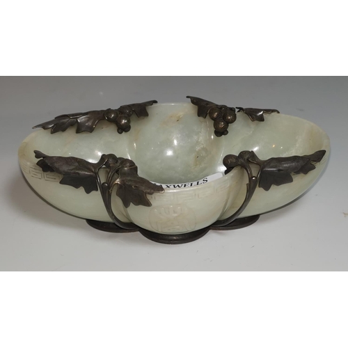 333 - A Chinese jade coloured hardstone dish of lobed oval form, decorated with stylized motifs in relief,... 