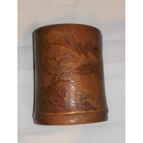 335 - A Chinese bamboo brush pot with light relief carving of a landscape, height 11 cm