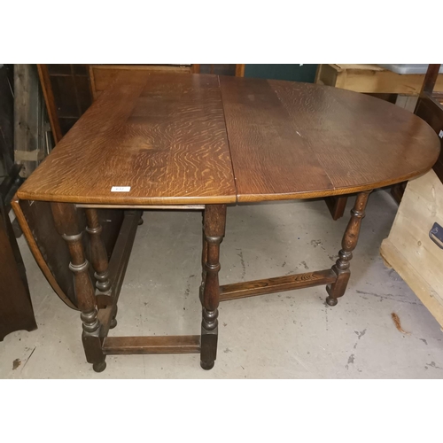 632 - A golden oak heavy drop leaf dining table with oval top, on turned legs, and 4 oak chairs with ladde... 
