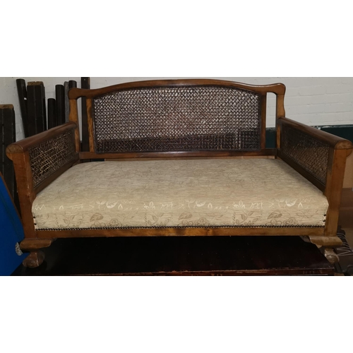 644 - A 1930's walnut bergère caned settee on ball and claw feet