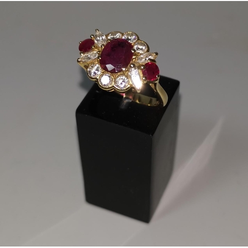 369 - An 18 carat hallmarked gold ruby and diamond dress ring, set oval central ruby and 2 rubies either s... 
