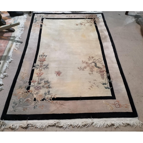 638 - A Chinese rug with cream ground, floral decoration and black border, 101