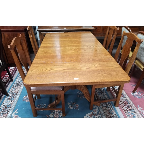 376 - A period style golden oak dining suite comprising rectangular drop leaf table and 4 'Country Chippen... 