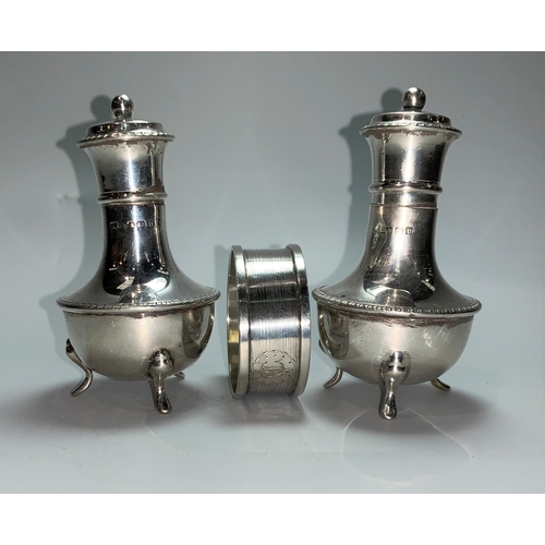 123 - A pair of silver pepper pots and a napkin ring