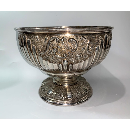 125 - A late 19th/early 20th century silver plated punch bowl with embossed decoration, on raised foot