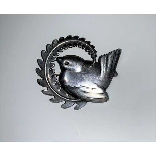 140 - A Georg Jensen silver brooch depicting a wren sitting within a curved fern branch, 5 cm, model no 30... 