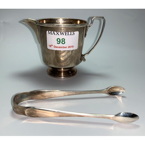 98 - A hallmarked silver milk jug, Birmingham 1940; a pair of hallmarked silver sugar tongs, 1918, 3.1 oz
