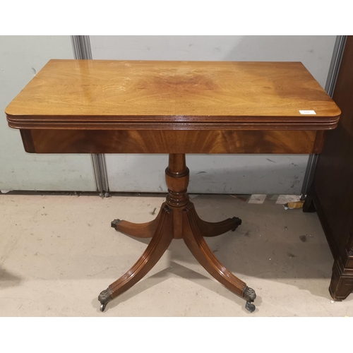 335 - A figured mahogany fold-over card table in the Georgian style, on turned column with quatrefoil base... 