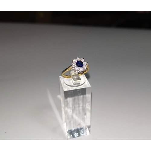 120 - A ladies dress ring set sapphire surrounded by 8 diamonds, 18 carat gold shank