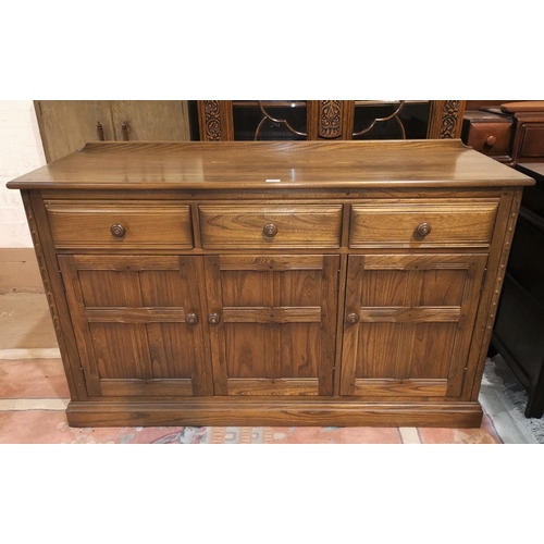318 - A modern Ercol elm sideboard of 3 cupboards and 3 drawers