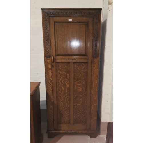 357 - A 1930's golden oak hall robe with carved decoration and panelled door