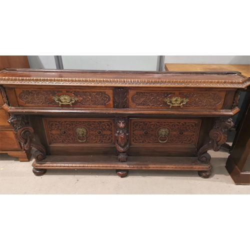 458 - A 19th century side table with extensive carving, 2 drawers and lion mask columns