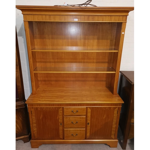 474 - A light mahogany reproduction full height bookcase with open front, drawers and cupboard to base