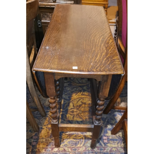 322 - A 1930's oak drop leaf table with oval top, on barley twist legs