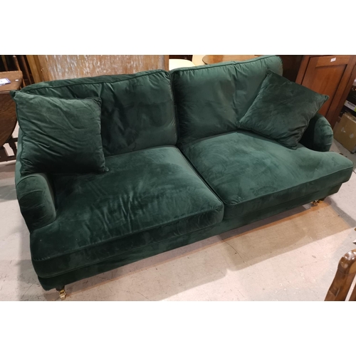352 - A Victorian style 3 seater settee in dark green velvet, on turned legs and castors
