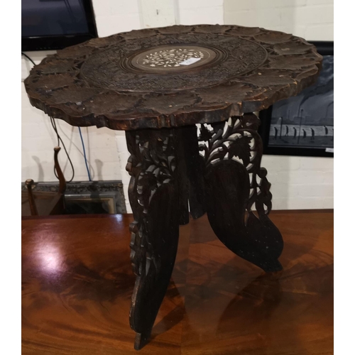 420 - An Indian carved hardwood occasional table  with circular top, on octagonal folding base, 53 cm